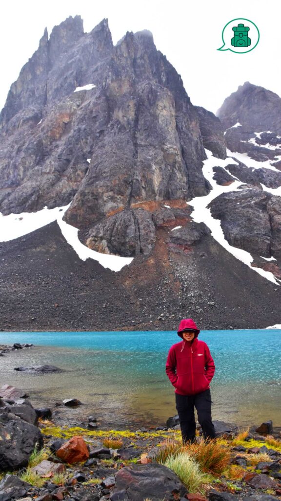 Mujer con mochila frente a laguna, con Cerro Duff al fondo.