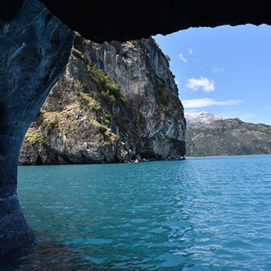 Vista interior de una caverna de mármol con luz filtrándose.