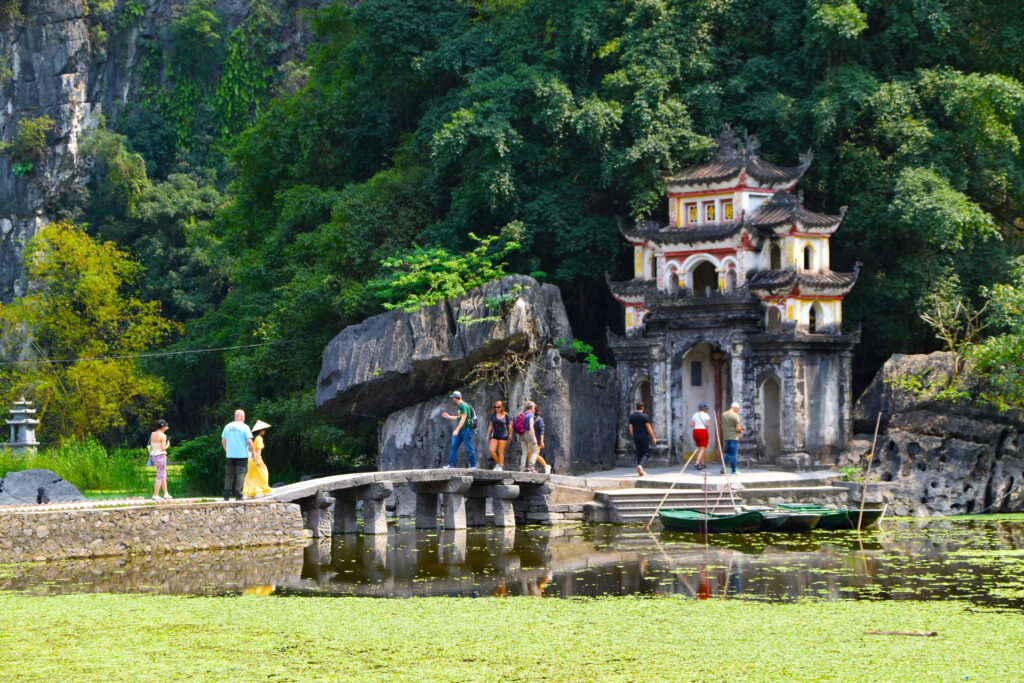 Pequeña edificación de estilo antiguo construida al pie de una montaña de roca en Ninh Binh.