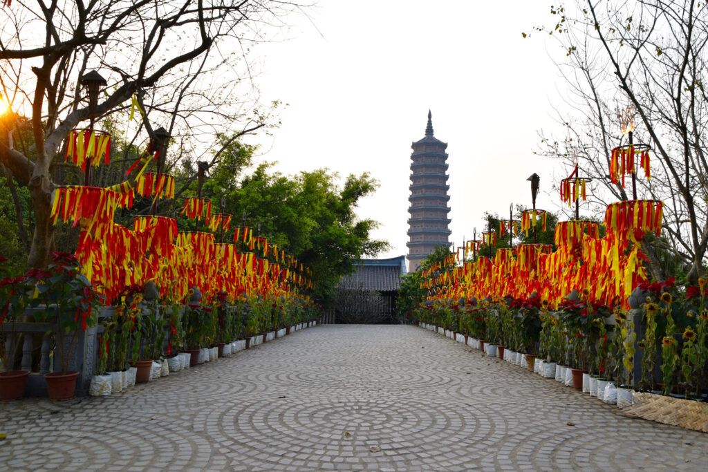 Sendero empedrado flanqueado por hileras de faroles rojos y amarillos en la Ruta en Ninh Binh Vietnam.