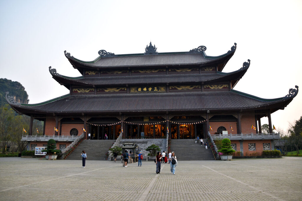 Gran templo budista de arquitectura tradicional con techos oscuros y múltiples niveles en Ninh Binh.