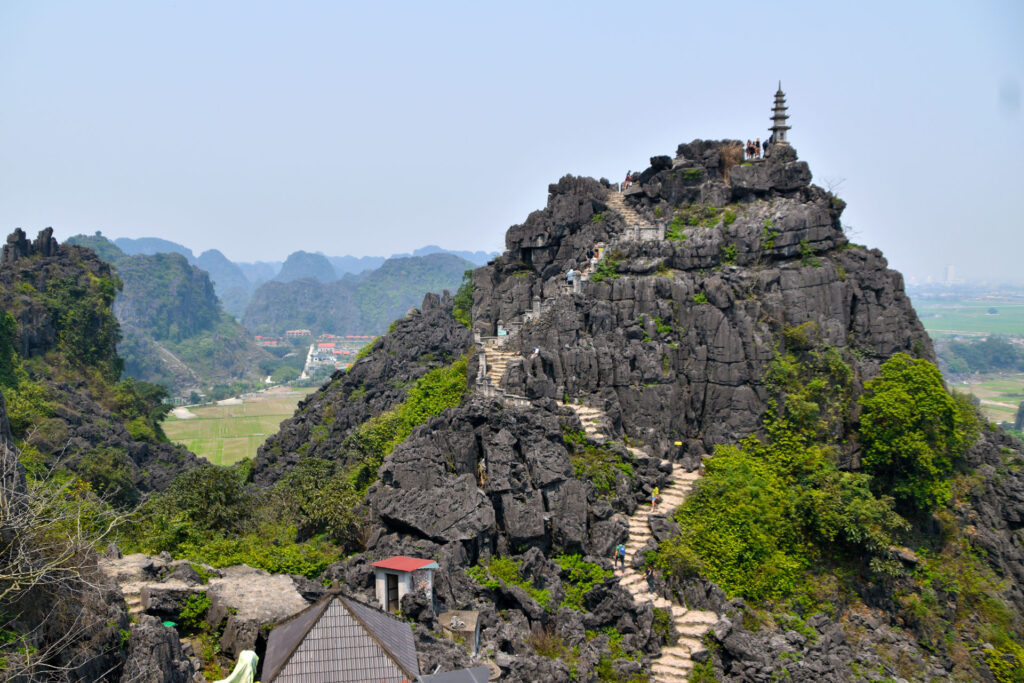 Vista de una pequeña pagoda en lo alto de una formación rocosa escarpada en Ninh Binh.
