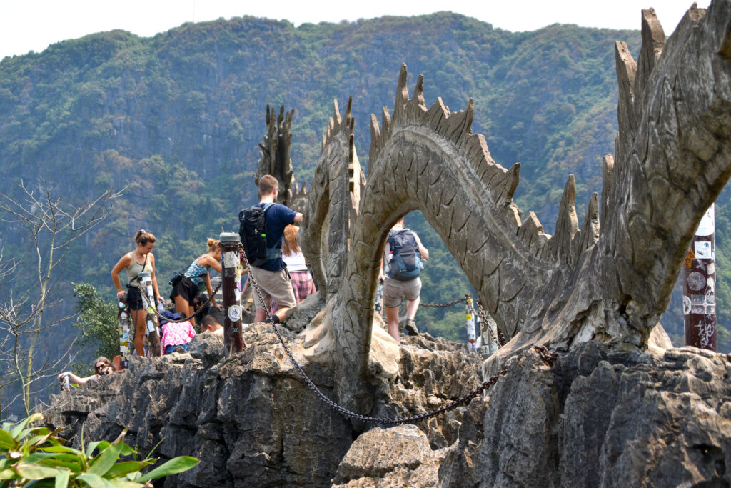Escultura detallada de un dragón de piedra en un mirador elevado de la Ruta en Ninh Binh Vietnam por Parche Y Le Cuento.